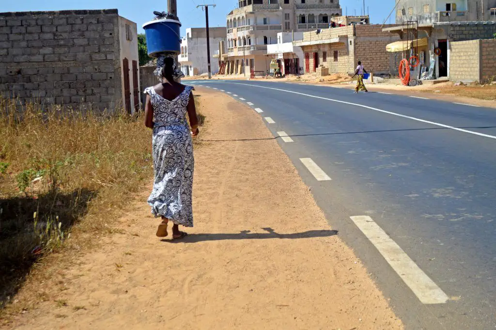 Una senegalesa camina junto a una autopista en Keur Massar